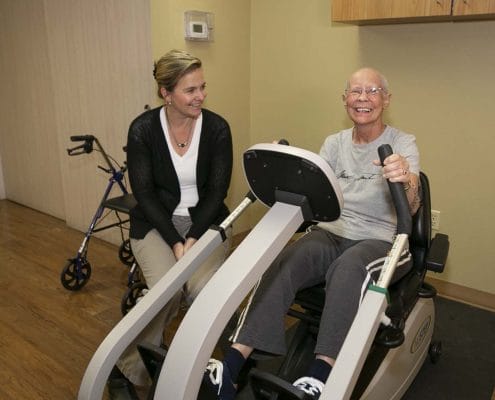 Senior resident exercising with staff assistance