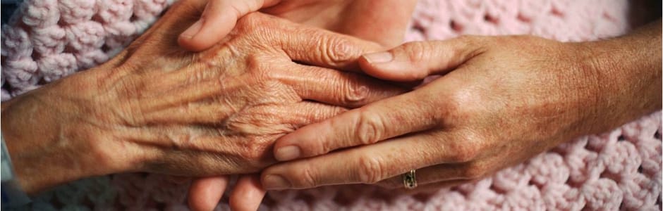 Caring hands of a resident and staff member