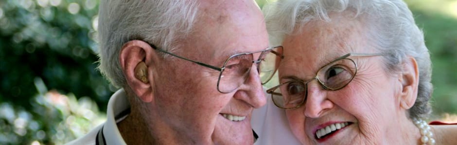 Elderly couple smiling together outdoors