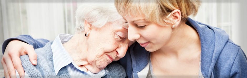 An elderly woman and a young caregiver sharing a moment together