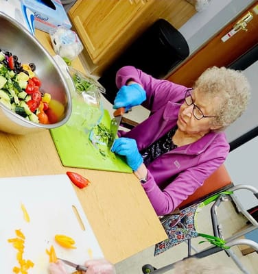 Resident preparing a fresh salad in the kitchen