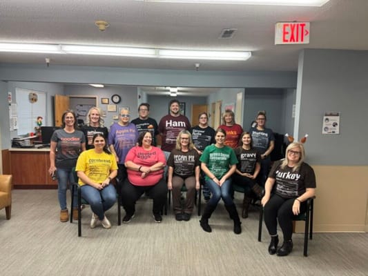 Staff members celebrating with themed shirts in a common area