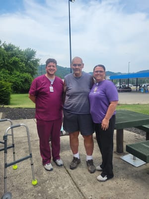 Residents and staff posing together outdoors.