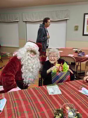 Resident with Santa during a holiday celebration