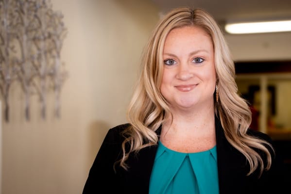 Staff member smiling in a facility corridor