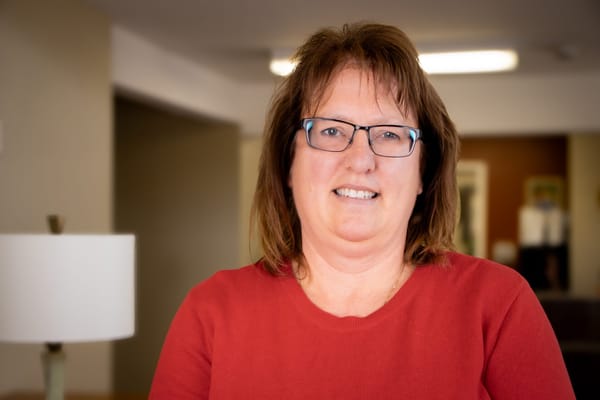 A staff member smiling in a warm, welcoming interior