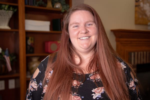 Staff member smiling in a cozy interior setting