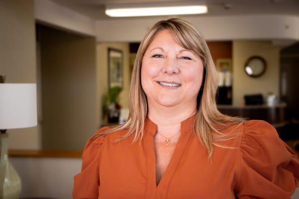 Staff member smiling in a bright facility lobby