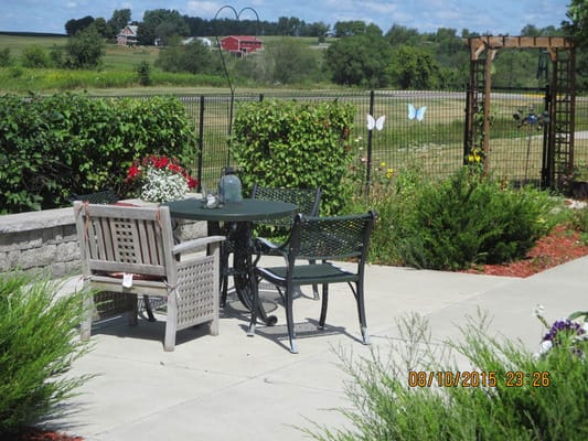 Outdoor seating area with flowers and greenery