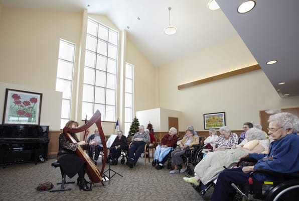 Residents enjoying a live harp performance in a common area