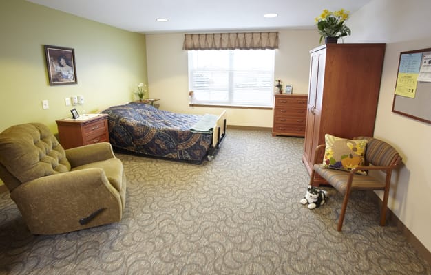 Cozy resident room with a bed and armchair