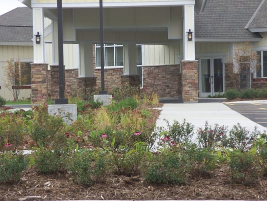 Entrance of a senior living facility with landscaped garden
