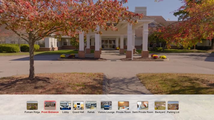 Front entrance of a senior living facility with fall-colored trees