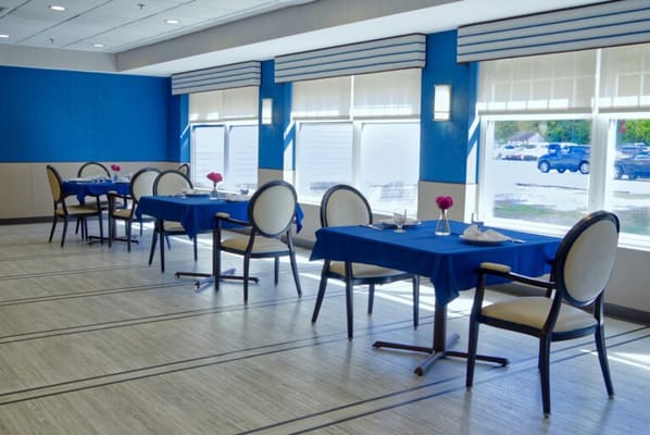 Dining area with blue table settings and flowers
