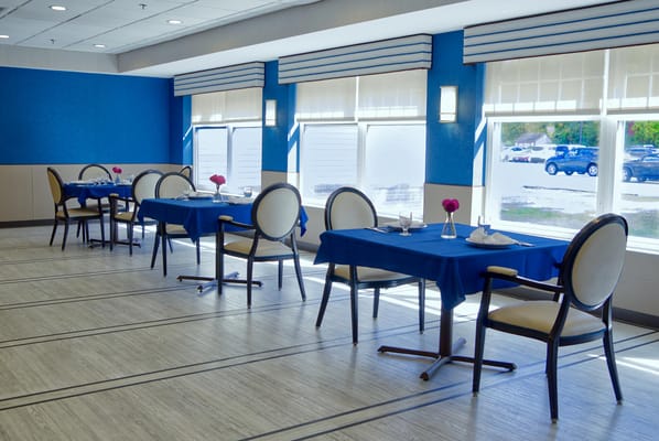 Dining area with blue table settings and flowers