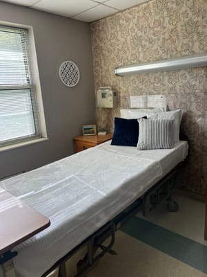 A well-furnished resident room with bedding and decor