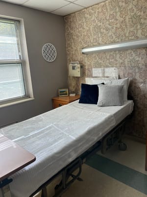 A well-furnished resident room with bedding and decor