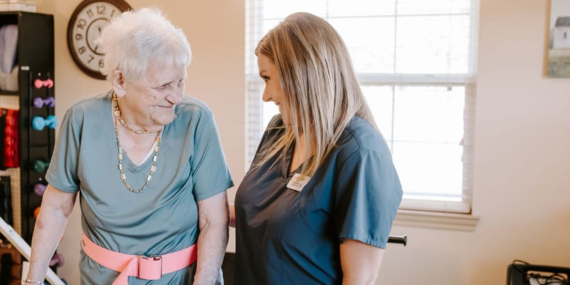 Senior resident interacting with staff in an activity room