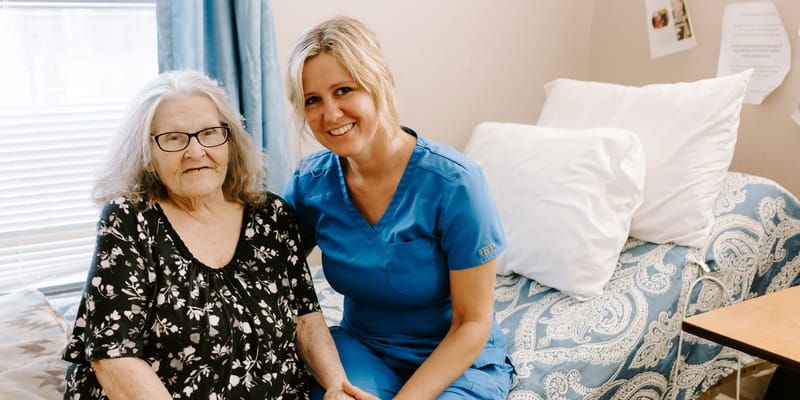 Resident and staff member smiling together