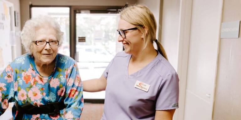 Staff assisting a resident in a hallway