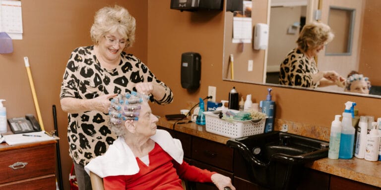 Stylist giving a hair treatment to a resident