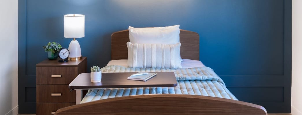 Cozy resident room with a bed and bedside lamp