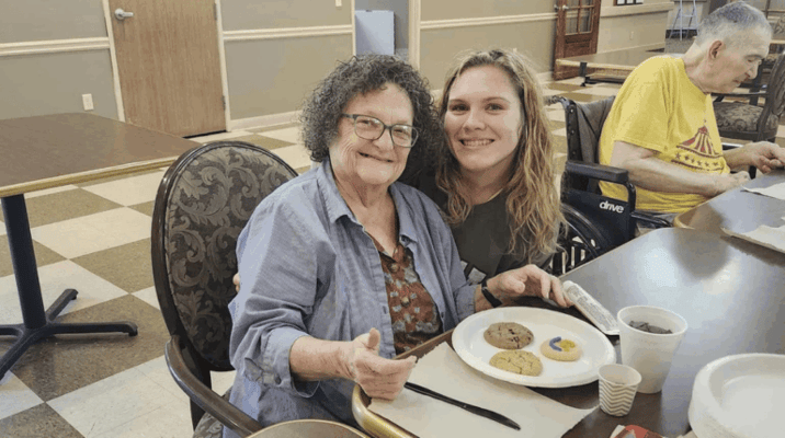 Resident and staff member enjoying cookies together