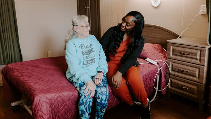 A caregiver interacting with a resident in her room