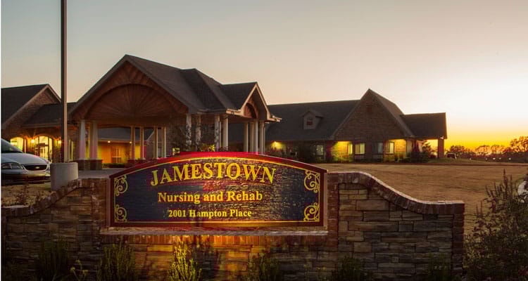 Exterior view of nursing home with signage at sunset