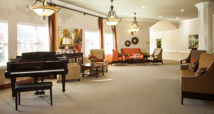 Bright common area with seating and a piano