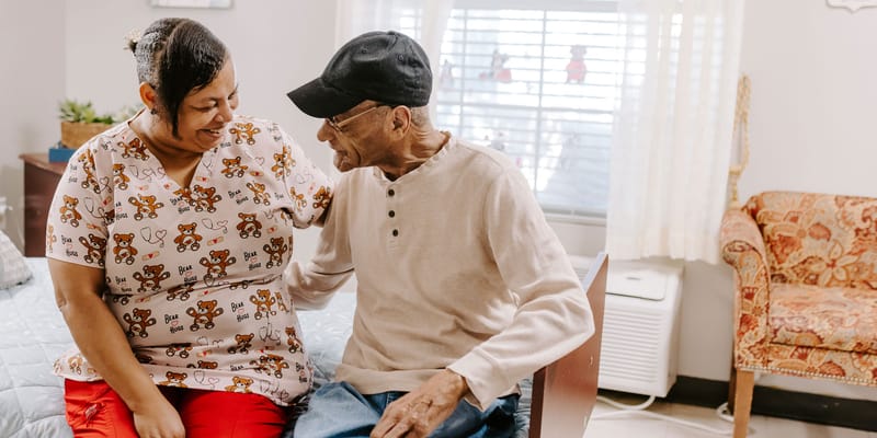 A caregiver and resident sharing a moment in a room