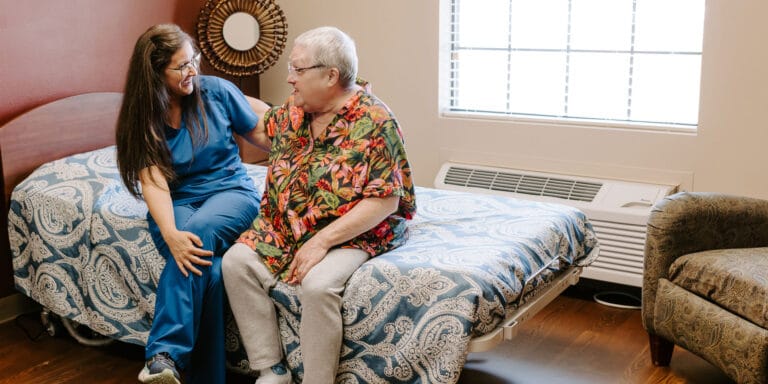 Staff member interacting joyfully with a resident in a room