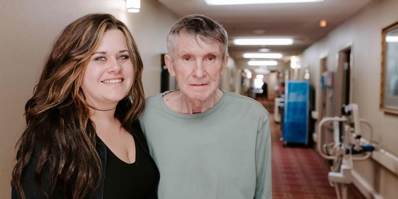 Resident with staff member in a hallway