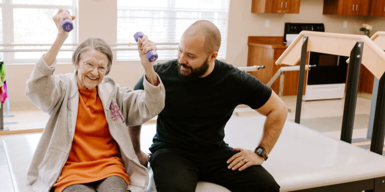 Resident exercising with a staff member in therapy session