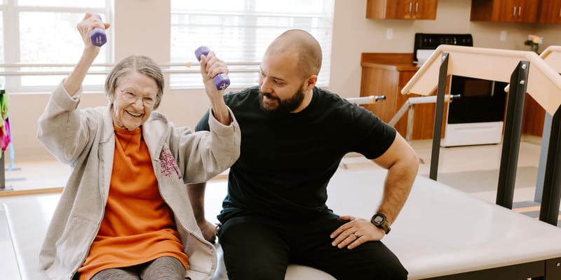 Resident exercising with a staff member in therapy session