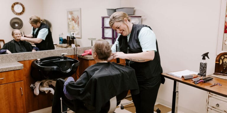 Hair salon scene with resident and staff member