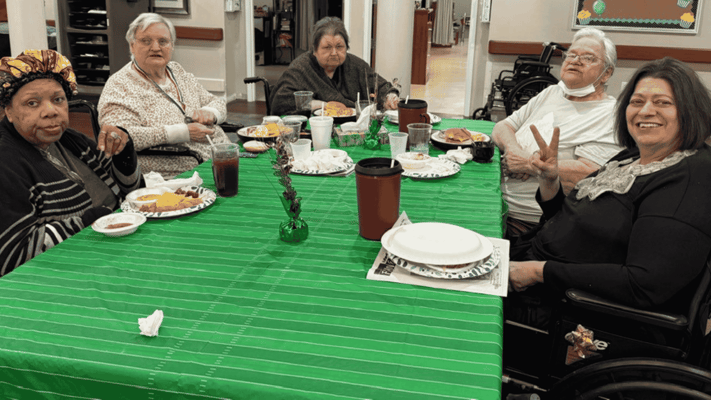 Residents enjoying a meal together in the dining room
