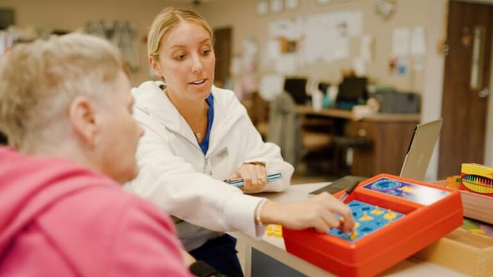 Resident engaging in a memory game with a staff member