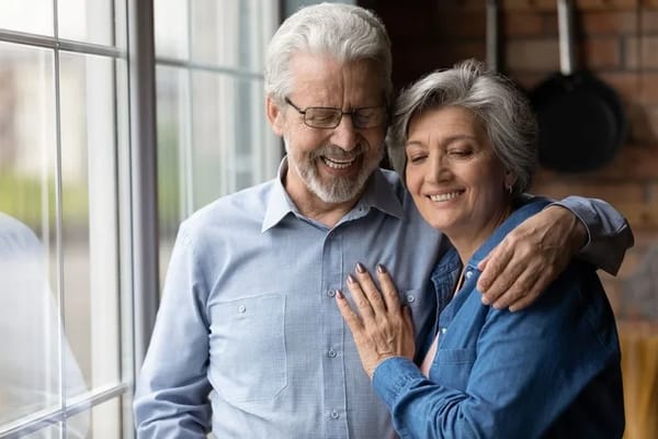Couple smiling together by a window