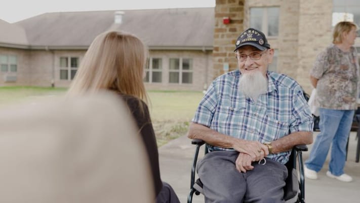 A resident and staff member chatting in an outdoor setting