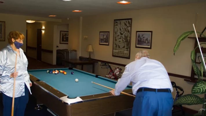 Residents enjoying a game of pool in a common area