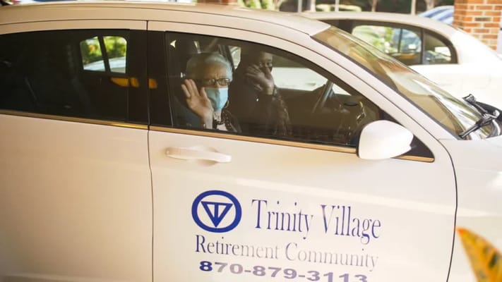 Residents waving from a transportation vehicle