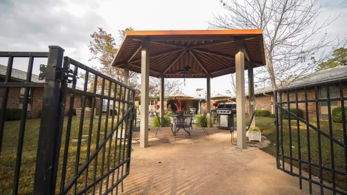 Outdoor gazebo with seating in a landscaped area