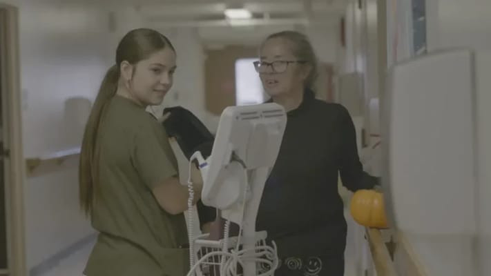 Staff assisting a resident in a hallway