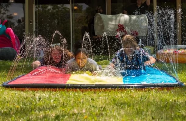 Residents enjoying a water slide activity in the garden