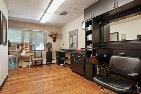 A hair salon area with styling chairs and a mirror