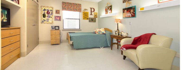 A cozy resident room with bed and armchair