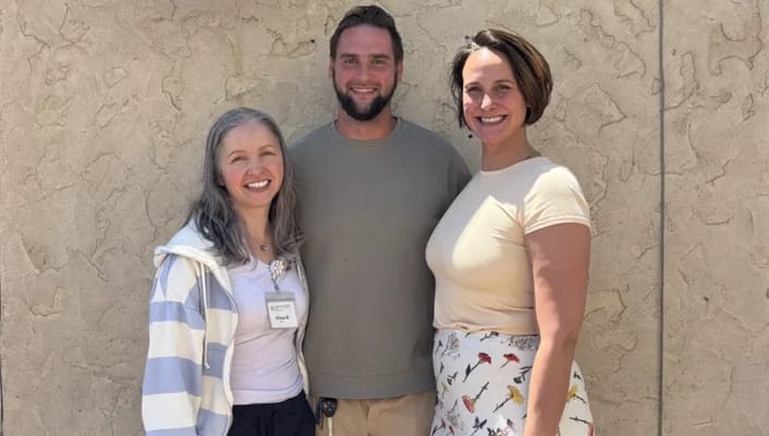Three staff members posing outdoors