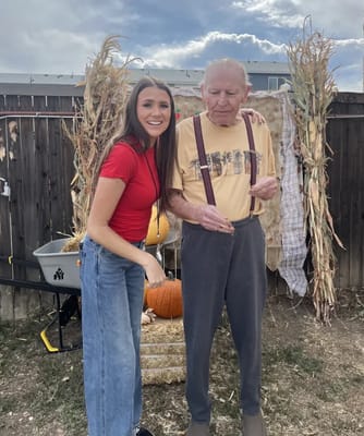 A resident and staff member enjoying a fall celebration outdoors