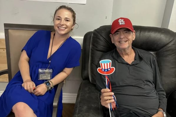 Resident and staff member celebrating with festive props